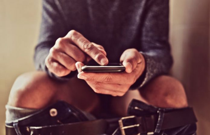 1_young-man-using-his-smartphone-in-the-toilet
